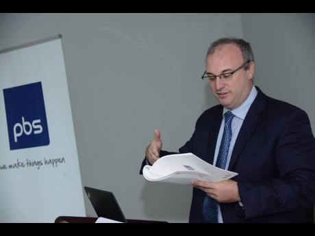 
Paul Scott, chairman of Productive Business Solutions Limited, peruses a report at the company’s annual meeting in September 2018.