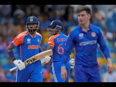 India’s Hardik Pandya (left) and batting partner Suryakumar Yadav (centre) run between the wickets during an ICC Men’s T20 World Cup cricket match against Afghanistan at Kensington Oval in Bridgetown, Barbados yesterday.