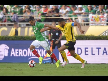 Mexico forward Jesus Manuel Corona (left) and Jamaica defender Adrian Mariappa battle for the ball during a Copa America match at the Rose Bowl, Thursday, June 9, 2016, in Pasadena, California. 