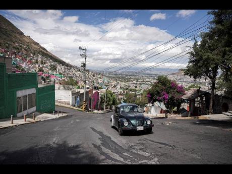 Janette Navarro drives her 1996 Volkswagen Beetle up a steep hill in the Cuautepec neighbourhood of Mexico City.