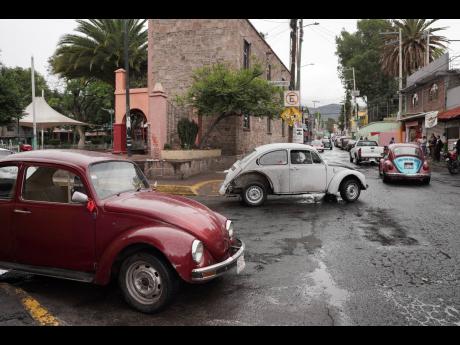 Volkswagen Beetles circulate offering taxi service in the hilly Cuautepec neighbourhood of Mexico City.