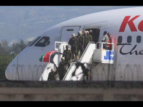 Police from Kenya disembark at the Toussaint Louverture International Airport in Port-au-Prince, Haiti, on Tuesday, June 25.