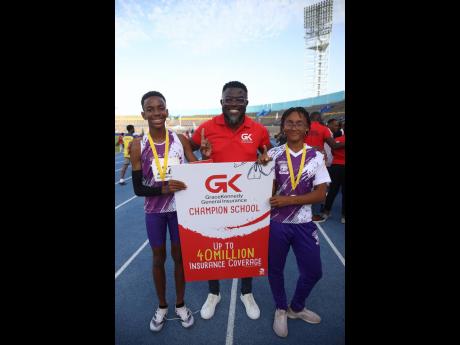 Orette Duncan, personal lines manager at GK General Insurance, is flanked by champion boy and champion girl, Donovan Leigh James (left) and Anya Johnson, both of Sts Peter and Paul Preparatory, 2024 winners of the 45th JISA Preparatory School Athletics Cha