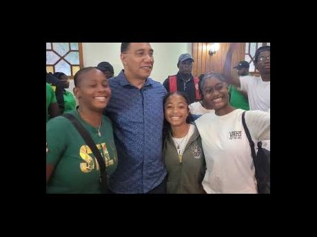 Prime Minister Andrew Holness with a group of young people during a meeting held at the Almond Tree Hotel and Restaurant in Ocho Rios, St Ann, on June 23.