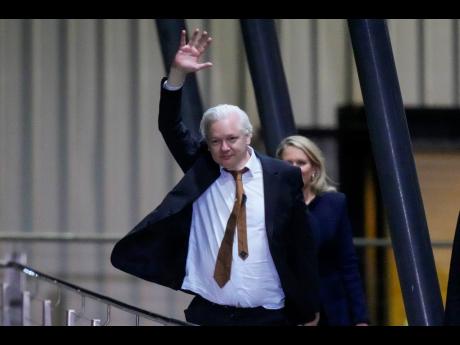 WikiLeaks founder Julian Assange waves after landing at RAAF air base Fairbairn in Canberra, Australia, Wednesday, June 26.