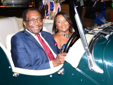 Though stationary for the evening, American Ambassador N. Nick Perry and his wife, Joyce, take a turn in the vintage car on display.