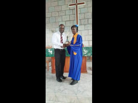 Nylah Martin (right), a final-year student at Negril Primary, collects her award from Sean Graham, principal of Maggotty High School. The award is one of several she received at a graduation ceremony on Tuesday.