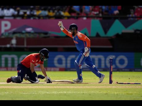 India wicketkeeper Rishabh Pant (right) celebrates after stumping England’s Moeen Ali during the ICC Men’s T20 World Cup second semi-final cricket match between the teams at the Guyana National Stadium in Providence, Guyana yesterday.