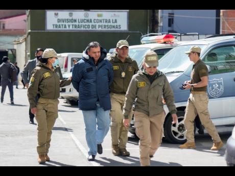 Former Air Force Commander Marcelo Zegarra is escorted by police in handcuffs in La Paz, Bolivia, yesterday. The government announced more arrests over their alleged involvement in what President Luis Arce called a coup attempt. 
