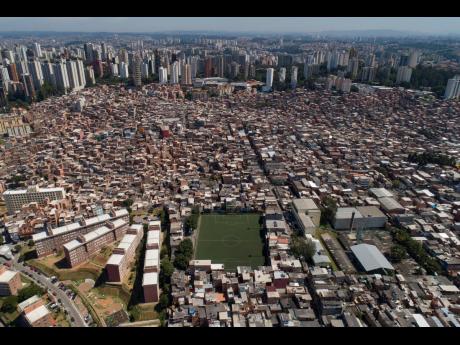 In this April 6, 2020 file photo, the slum Paraisopolis, which is the combination of the words “Paradise” and “Metropolis,” stands next to the upper class Morumbi neighbourhood, top, in São Paulo, Brazil. 
