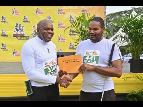 Contributed 
Senator, Professor Floyd Morris (left) presents his personal donation to the Jamaica Society for the Blind’s Vision Centre’s  Scholarship Fund to Daemion McLean, the organisation’s chairman, at The Best Dressed Chicken/Everyone’s a Win