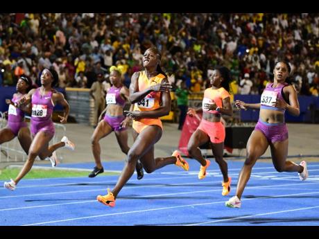 Gladstone Taylor/Multimedia Photo Editor 
Tia Clayton (right) finishes second behind a celebrating Shericka Jackson (second right) in the women’s 100-metre final at the JAAA/PUMA National Junior and Senior Championships inside the National Stadium on Fri