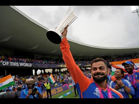 AP 
India’s Virat Kohli raises the winners’ trophy as he celebrates after India won the ICC Men’s T20 World Cup final cricket match against South Africa at Kensington Oval in Bridgetown, Barbados yesterday.