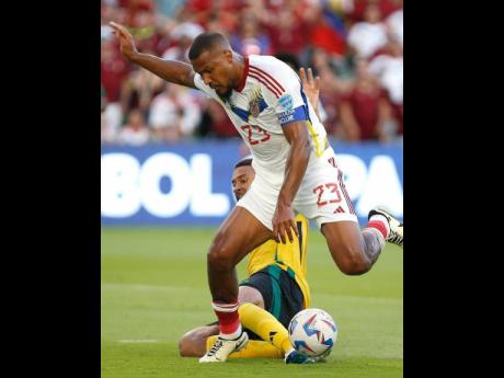 Venezuela’s Salomón Rondón shrugs off the challenge of Jamaica’s Michael Hector during a Copa America Group B football game  at the Q2 Stadium in Austin, Texas, yesterday.