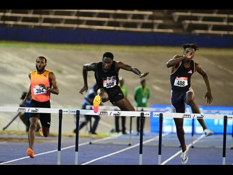 Jaheel Hyde (left) goes in chase of fast-finishing Malik James-King (centre), and Roshawn Clarke during the JAAA/PUMA National Junior and Senior Championships inside the National Stadium on Friday.
