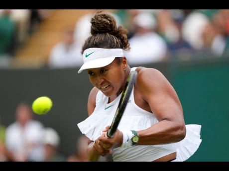 Naomi Osaka of Japan plays a backhand return to Diane Parry of France during their first-round tennis match at Wimbledon Tennis Championships in London yesterday.