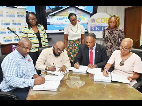 Seated, from left: Gawayne Murdock, managing director of GDM Associates Ltd; Clive Wint, managing director, C and D Construction; Omar Sweeney, managing director, Jamaica Social Investment Fund (JSIF); and Education Minister Fayval Williams signing the con