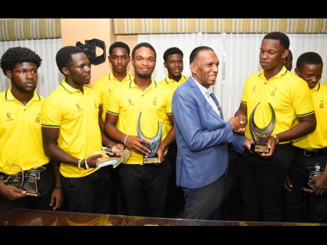 Former Jamaica Cricket Association president Wilford “Billy” Heaven (second right)  greets Brian Barnes, (right) captain of the under-19 team after their triumphant return from the CWI Rising Stars under-19 tournament.