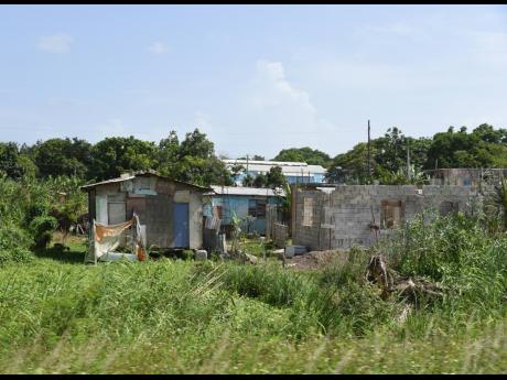 Several zinc-roofed houses and an unfinished structure in the swampy Zion community in Martha Brae, Trelawny.