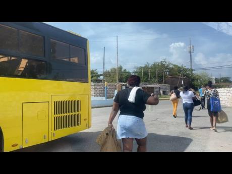 Passengers disembark a Jamaica Urban Transit Company bus in Port Royal on Tuesday.