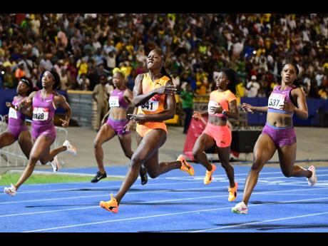 Tia Clayton (right) finishes second behind a celebrating Shericka Jackson (second right) in the women’s 100-metre final at the JAAA/PUMA National Junior and Senior Championships inside the National Stadium recently.