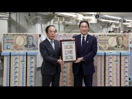 Japanese Prime Minister Fumio Kishida, right, and Bank of Japan Governor Kazuo Ueda hold the country’s new banknotes in a frame, during a ceremony to mark the release of the banknotes, at the BOJ headquarters in Tokyo, Japan, Wednesday, July 3, 2024.