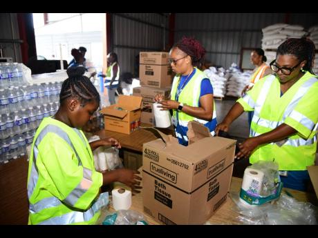 Unnamed persons from Food For The Poor Jamaica prepare relief packages for persons affected by Hurricane Beryl on Thursday, July 4, a day after the passage of the storm.