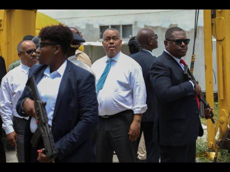 Haitian Prime Minister Garry Conille (centre) is surrounded by security as he arrives at the General Hospital in Port-au-Prince, Haiti, yesterday. The prime minister and police chief visited the capital’s largest hospital after authorities announced that