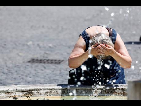 A woman cools off at a fountain in downtown Rome, Thursday, July 11, 2024. (Cecilia Fabiano/LaPresse via AP)