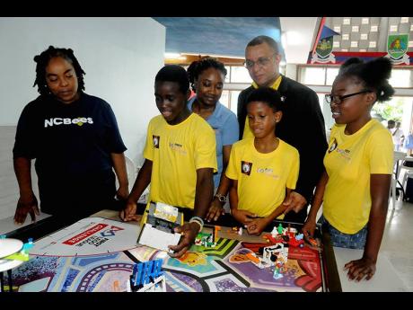 Donovan Wilson (back row, right), president of the Union of Jamaica Alumni Association joins Jamilia Crooks-Brown (left), programmes administrator of NCB Foundation and Dezion Duhaney (back row, left), project assistant of FIRST Tech Jamaica Challenge Jama