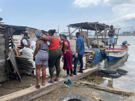 Relatives identify the body of Alric Moncrieffe after it was recovered from mangroves near Petrojam in Kingston on Thursday. The 26-year-old security guard had been missing 
since last Wednesday.