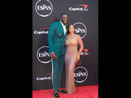 Hazel Renee donned an iridescent mesh dress while posing with her husband, Draymond Green, who sported a teal suit with velvet green loafers to match.