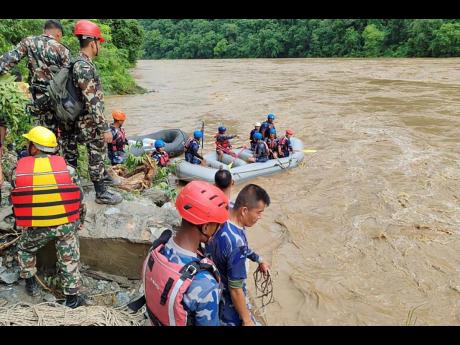 Rescuers looking for survivors after two buses were swept by a landslide off the highway and into a swollen river near Simaltal, about 120 kilometres west of the capital, Kathmandu, Nepal on Friday.