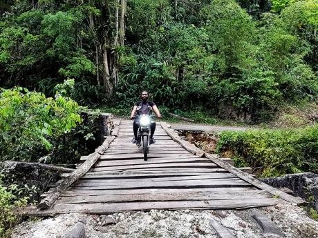 A motorcyclist utilising the Woodsville bridge constructed by members of the community.