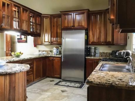 The auxiliary kitchen in polished wood and granite countertops.