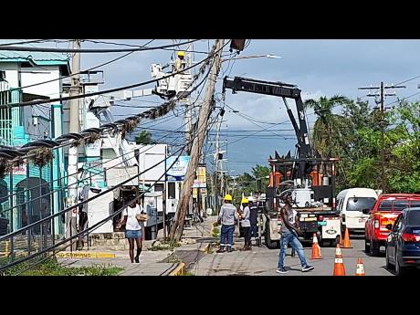 Jamaica Public Service technicians repair light wires, poles and transformers at Barracks Road in Savanna-la-Mar, Westmoreland.