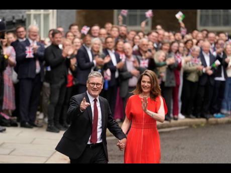 
Britain’s Labour Party Prime Minister Keir Starmer and his wife Victoria arrive in Downing Street and greet supporters in London, Friday, July 5.