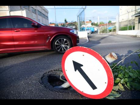 On July 2, 2024, a motorist was seen navigating their way along Constant Spring Road in the vicinity of Oakland Apartments where a section of the roadway collapsed, a day ahead of the passage of Hurricane Beryl.