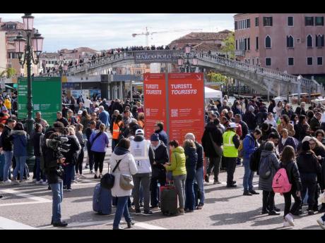 Stewards check tourists’ QR code access outside the main train station in Venice, Italy, on April 25. 