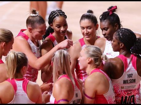 Thunderbirds and Sunshine Girls trio, Latanya Wilson (right), Romelda Aiken-George (second right) and Shamera Sterling-Humphrey (centre) help get their team ready for a Suncop Super Netball League game.