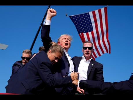 Republican presidential candidate, former President Donald Trump, is surrounded by US Secret Service agents at a campaign rally in Butler, Pennsylvania, on Saturday.