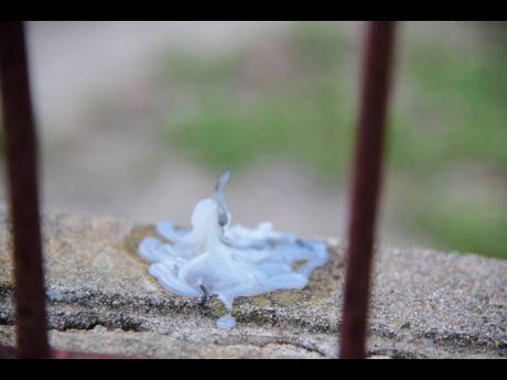 A melted candle stains a wall at Neisha’s home on Monday. The candles were from a remembrance event on Sunday evening.