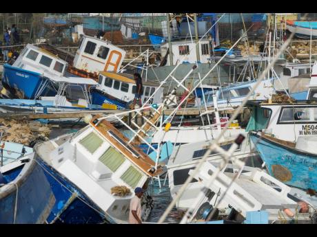 A fisherman looks at fishing vessels damaged by Hurricane Beryl at the Bridgetown Fisheries in Barbados, Monday, July 1, 2024.