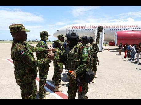 Kenyan police that are part of a UN-backed multinational force welcome more Kenyan police after their plane landed at Toussaint Louverture International Airport in Port-au-Prince, Haiti, yesterday.