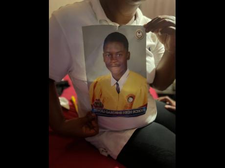 Marguerita Rainford shows the high school graduation photo of her son, 20-year-old Tyrique McLish, who was killed on Monday.