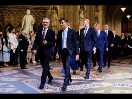 Prime Minister Sir Keir Starmer (left) and Conservative leader Rishi Sunak (right) lead MPs through the Central Lobby at the Palace of Westminster, ahead of the State Opening of Parliament in London yesterday.