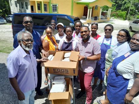 Custos of Hanover, and board member of Hanover Charities, Dr. David Stair (left), was on hand at the Hopewell Church of God of Prophecy to assist with the delivery of lunches prepared under the feeding programme being implemented by the church through the 