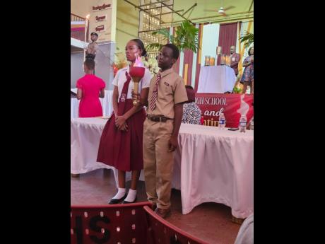 Jomar Clue (right), the top Primary Exit Profile matriculant at Glenmuir High for 2024, carries the torch with Rayonna Beason, the Clarendon-based school’s top performer in the 2023 Caribbean Secondary Education Certificate exams, at the Torch Lighting C