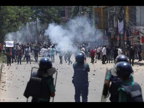 Students clash with riot police during a protest against a quota system for government jobs, in Dhaka, Bangladesh, yesterday.