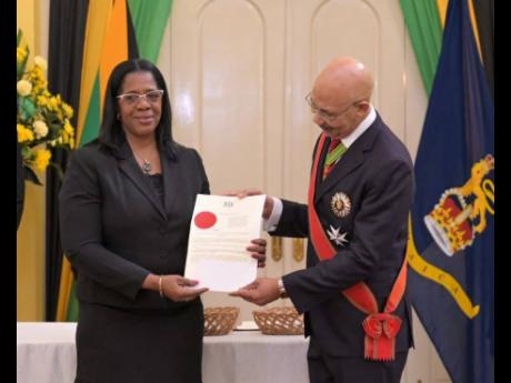 Governor General Sir Patrick Allen (right) presents newly appointed president of the Court of Appeal, Justice Marva McDonald-Bishop, with the instrument of appointment at the swearing-in ceremony held at King’s House on Thursday.